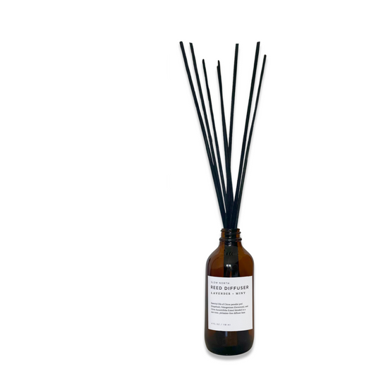 Reed diffuser with black reeds and a brown bottle on a white background